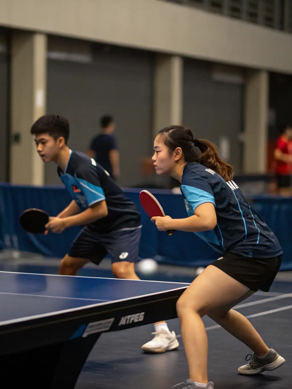 A dynamic shot of a table tennis match in progress, capturing the focus and excitement of the players at D.S.S.R.
